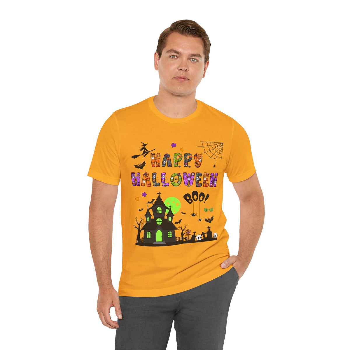 A man wearing a yellow t-shirt with a colorful Happy Halloween text and haunted house design.