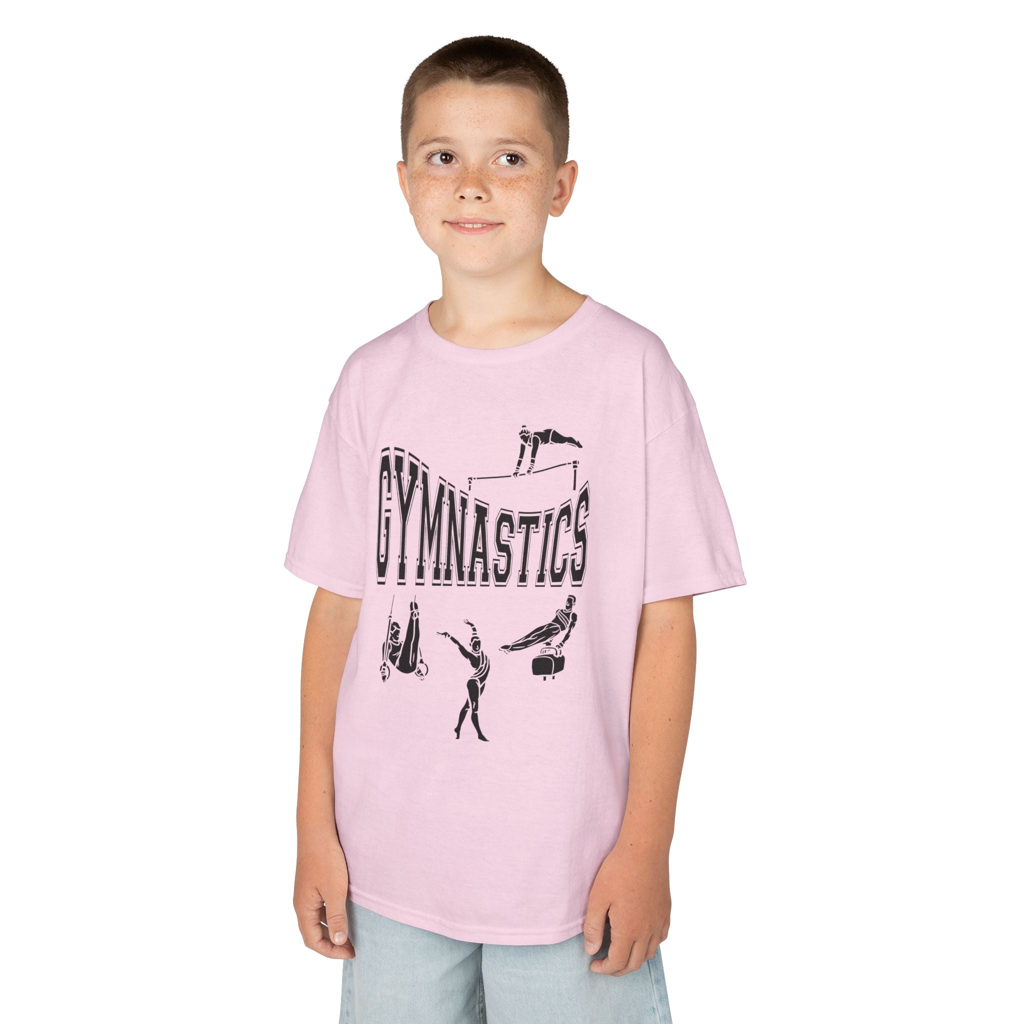 Young boy wearing a youth Gildan 5000B heavy cotton t-shirt in light pink with a gymnastics text and graphic