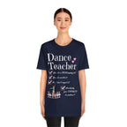 A young woman wearing a navy short-sleeve crewneck t-shirt featuring a text that reads Dance Teacher and a ballet class graphic.