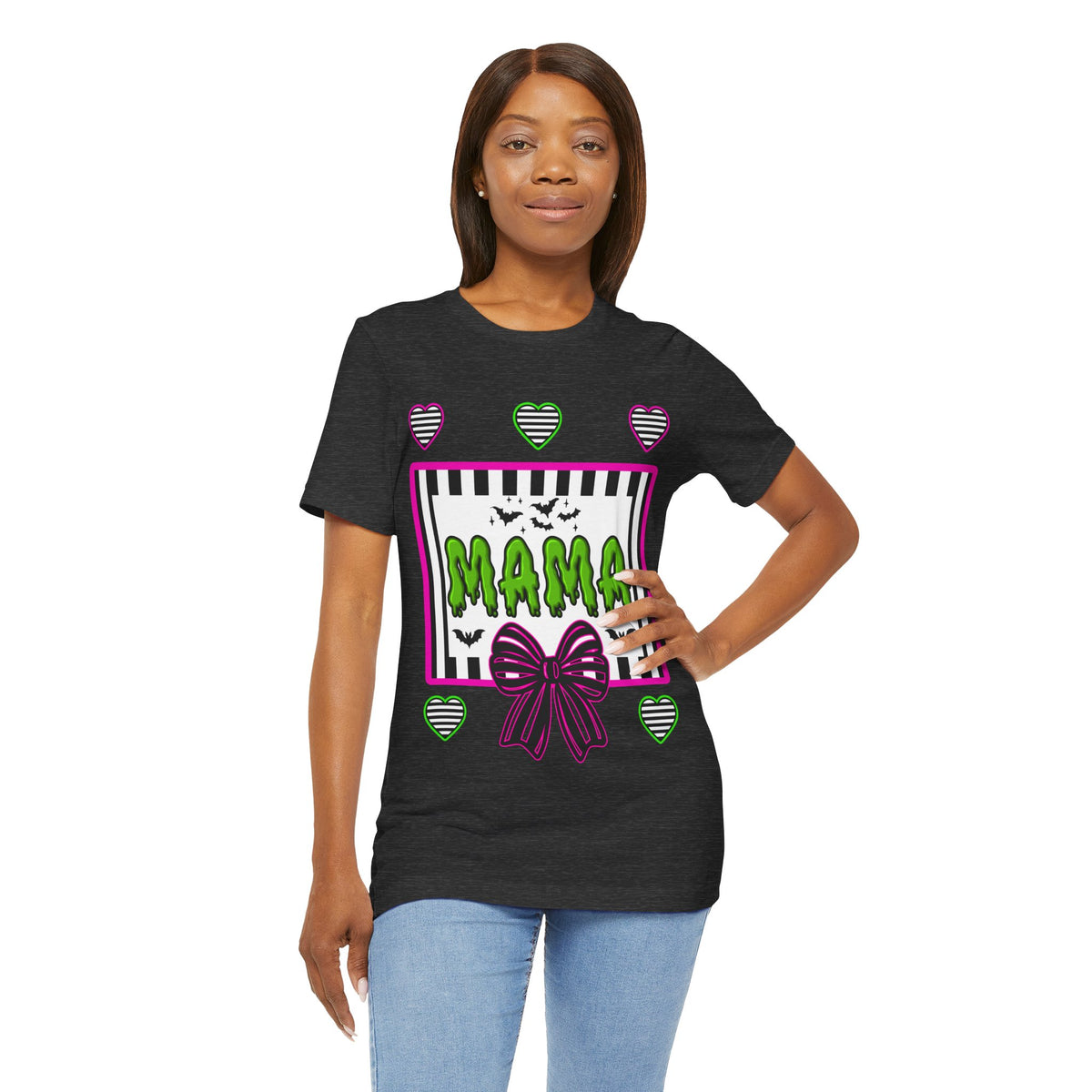 A woman wearing a dark grey t-shirt featuring a colorful Beetlejuice inspired Halloween-themed graphic with MAMA on the front.