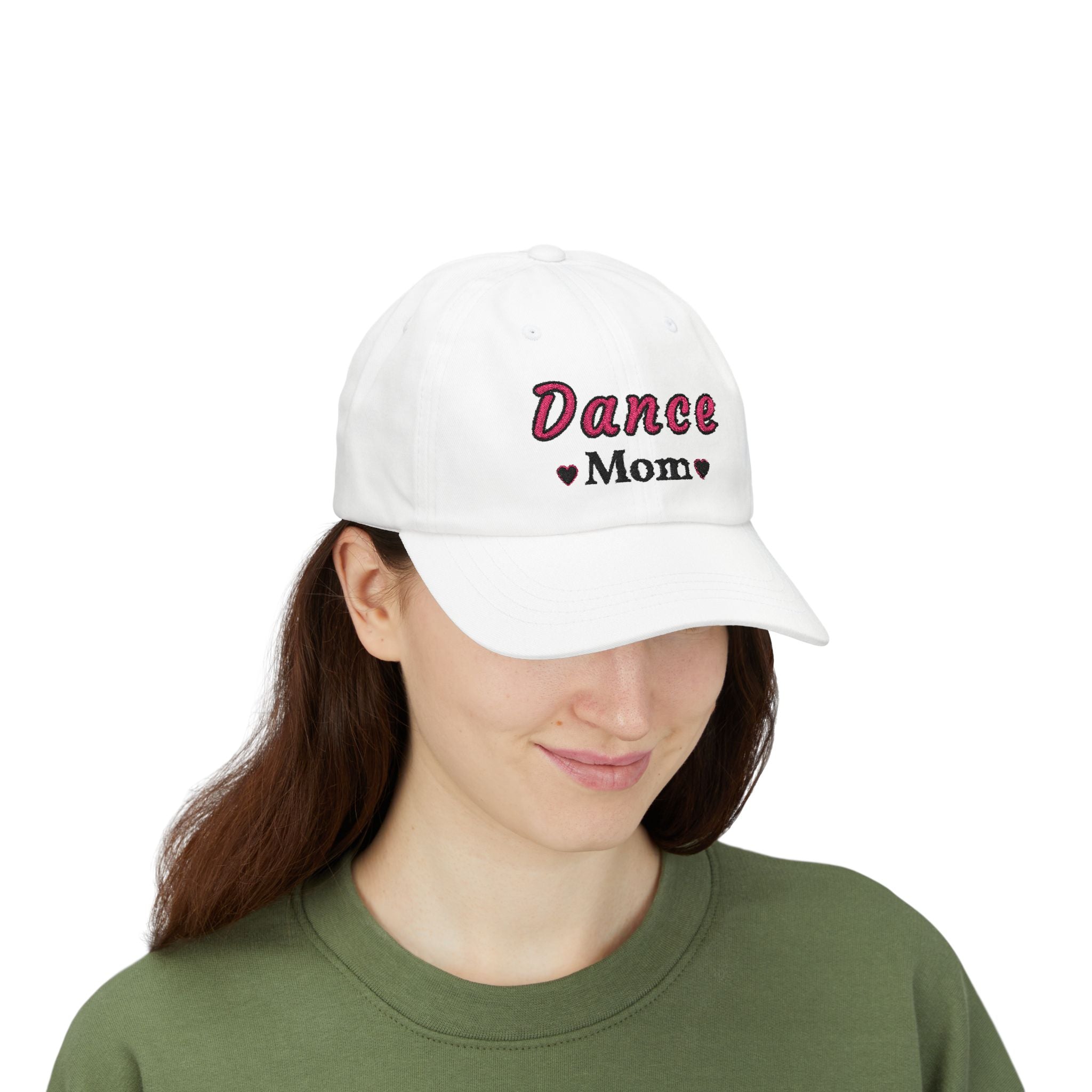 A woman wearing a white baseball cap featuring the embroidered text Dance Mom on the front. 