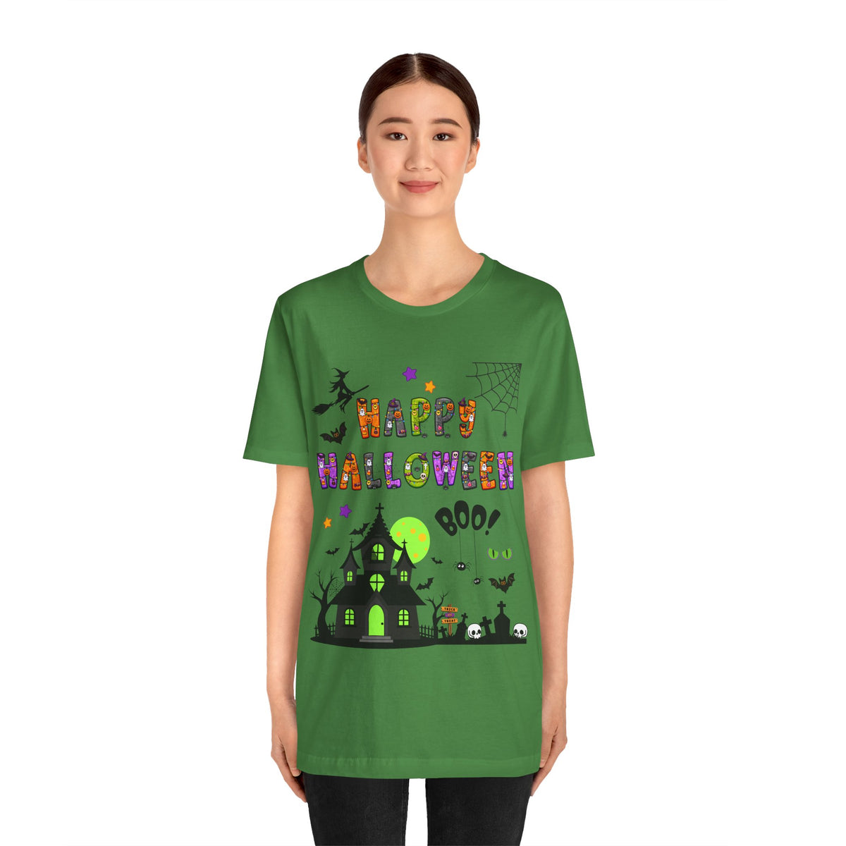 A woman wearing a green t-shirt with a colorful Happy Halloween text and haunted house design.