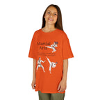 Young girl wearing a youth Gildan 5000B heavy cotton t-shirt in orange with a Martial Arts text and graphic