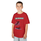 Young boy wearing a youth Gildan 5000B heavy cotton t-shirt in red with a Swimming text and graphic