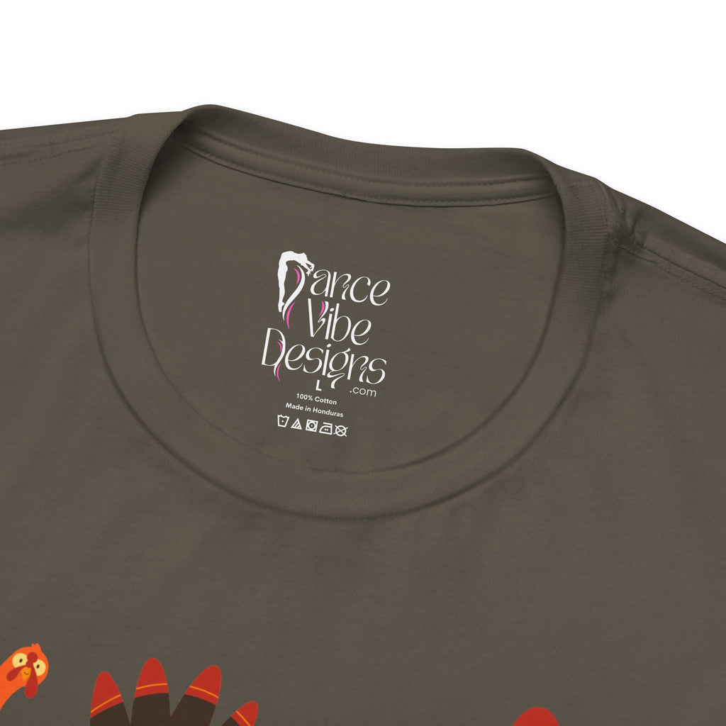 Close-up of an army green t-shirt showing the inner neck label with Dance Vibe Designs LLC printed in white, alongside care instructions.