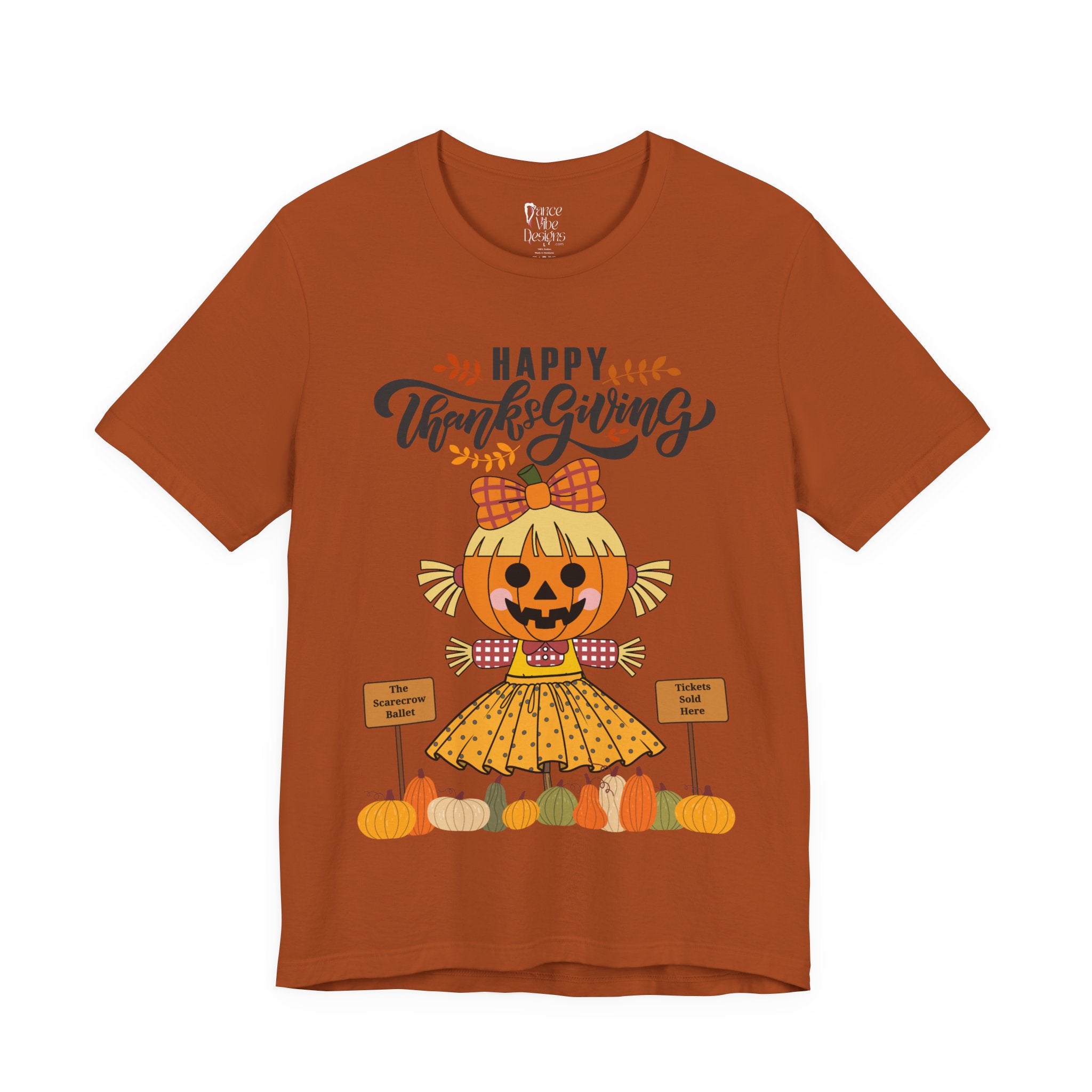 An autumn short-sleeve t-shirt with a Happy Thanksgiving graphic featuring a ballerina scarecrow design.