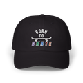 A black baseball cap featuring a graphic on the front that reads BORN TO SKATE with a skateboard illustration. 