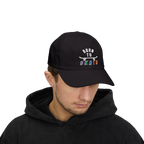 Man wearing a black baseball cap featuring a graphic on the front that reads BORN TO SKATE with a skateboard illustration. 